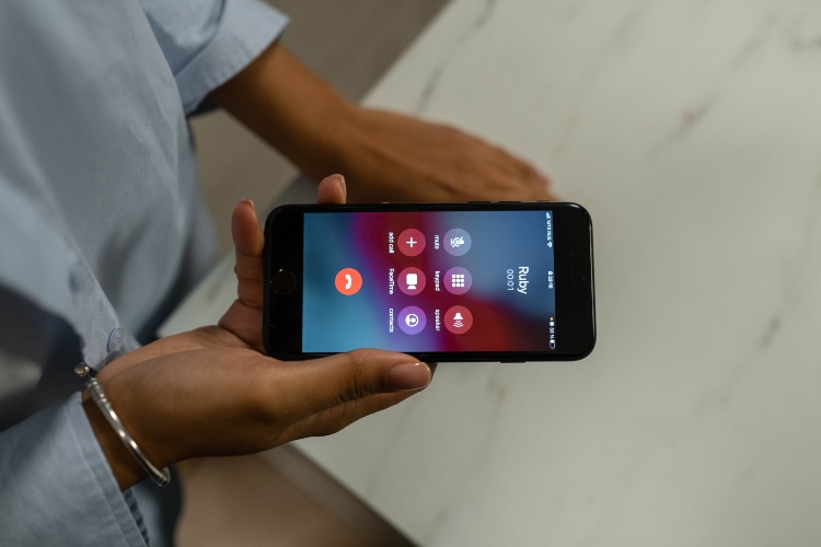 Persona rechaza una llamada sospechosa en su teléfono móvil para evitar una posible estafa telefónica y proteger su información personal.