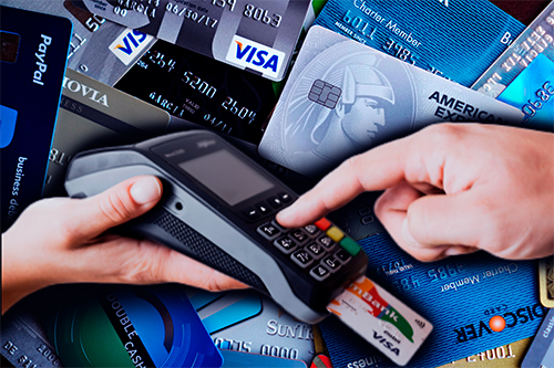 Persona comparando diferentes tarjetas de crédito y revisando costos financieros desde una aplicación bancaria en su teléfono móvil.